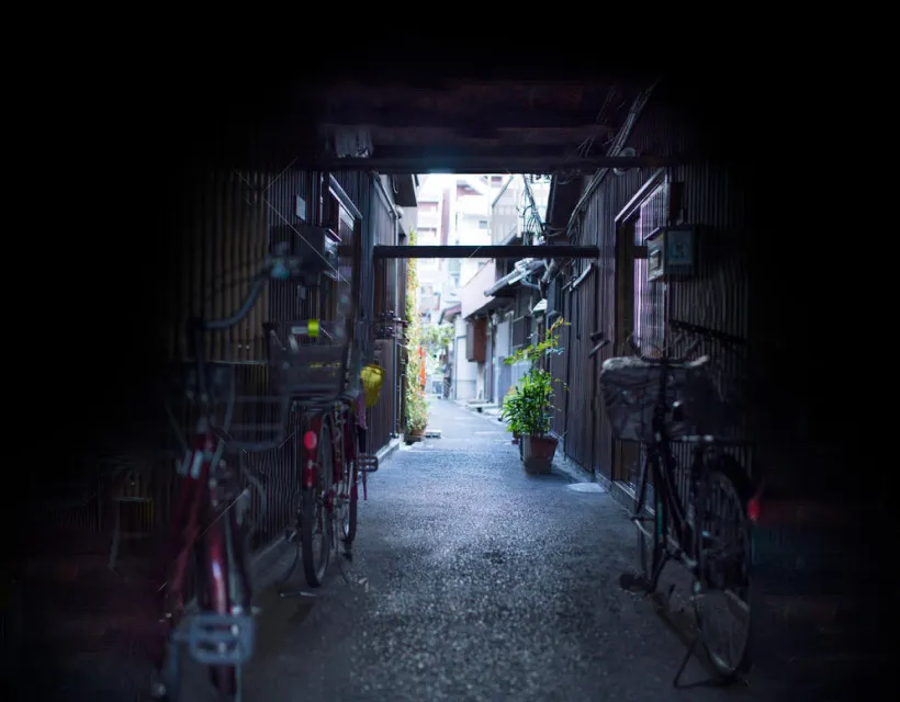 暗い通路の先に、明るい路地が続いている中崎町の風景