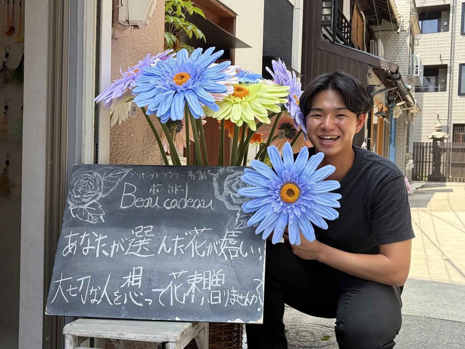 花屋の店先で花を持つ爲本滉太さん