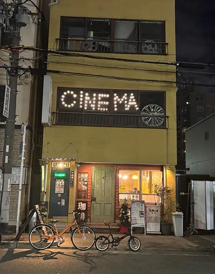 夜に明かりが灯る小さな映画館の外観